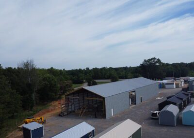 Aerial view of a storage facility with various sheds and greenery in the background.